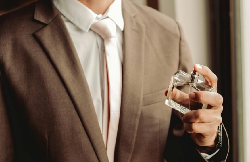 man wearing suit and necktie with perfume bottle